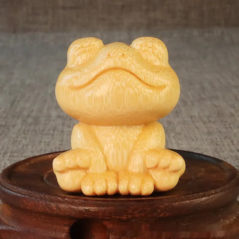 Solid bamboo carving of a cartoon smiling frog ornament, 5cm tall.