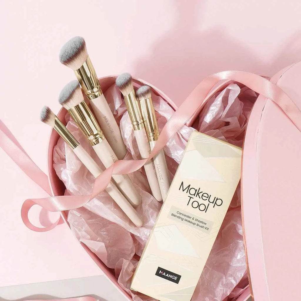 MAANGE five apricot coloured makeup brushes with angled blush brush on pink surface