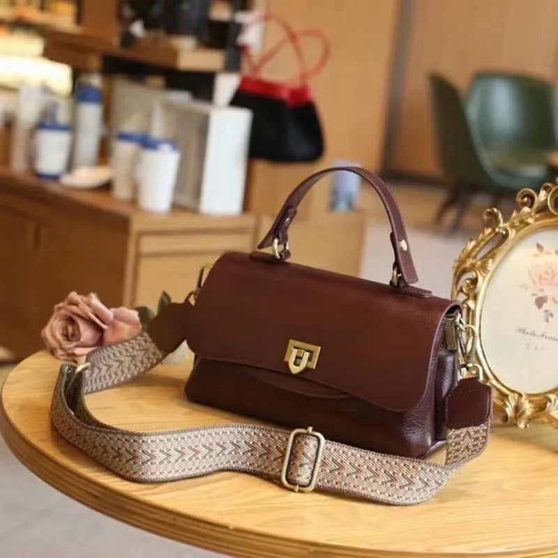 Women's dark brown genuine leather saddle back handbag with multiple compartments and shoulder straps