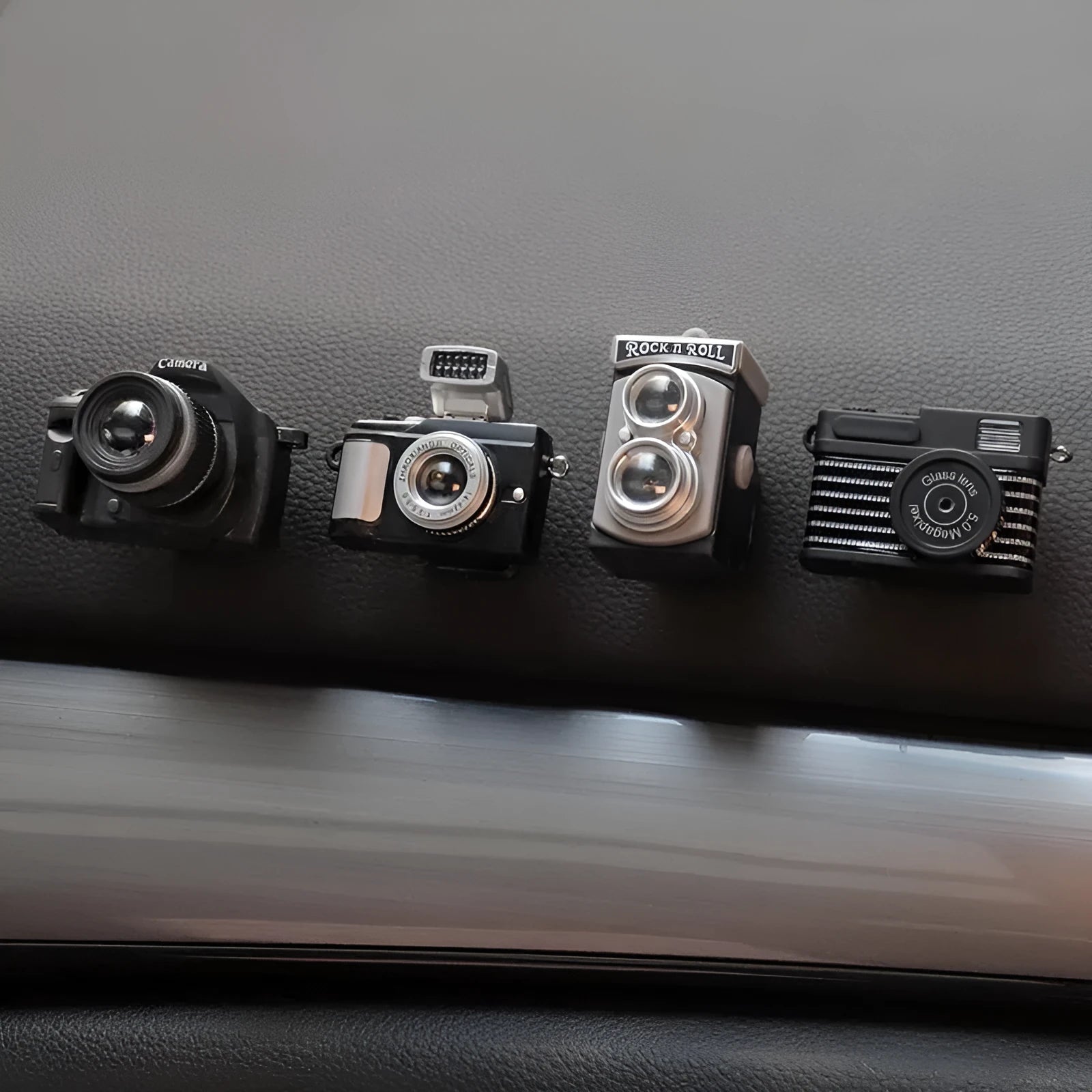 Pack of four retro camera dot design adhesive hooks for car interiors.
