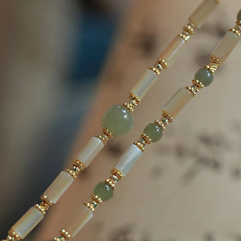 Handmade women's Hetian jade bracelet with round beads in geometric design on wrist