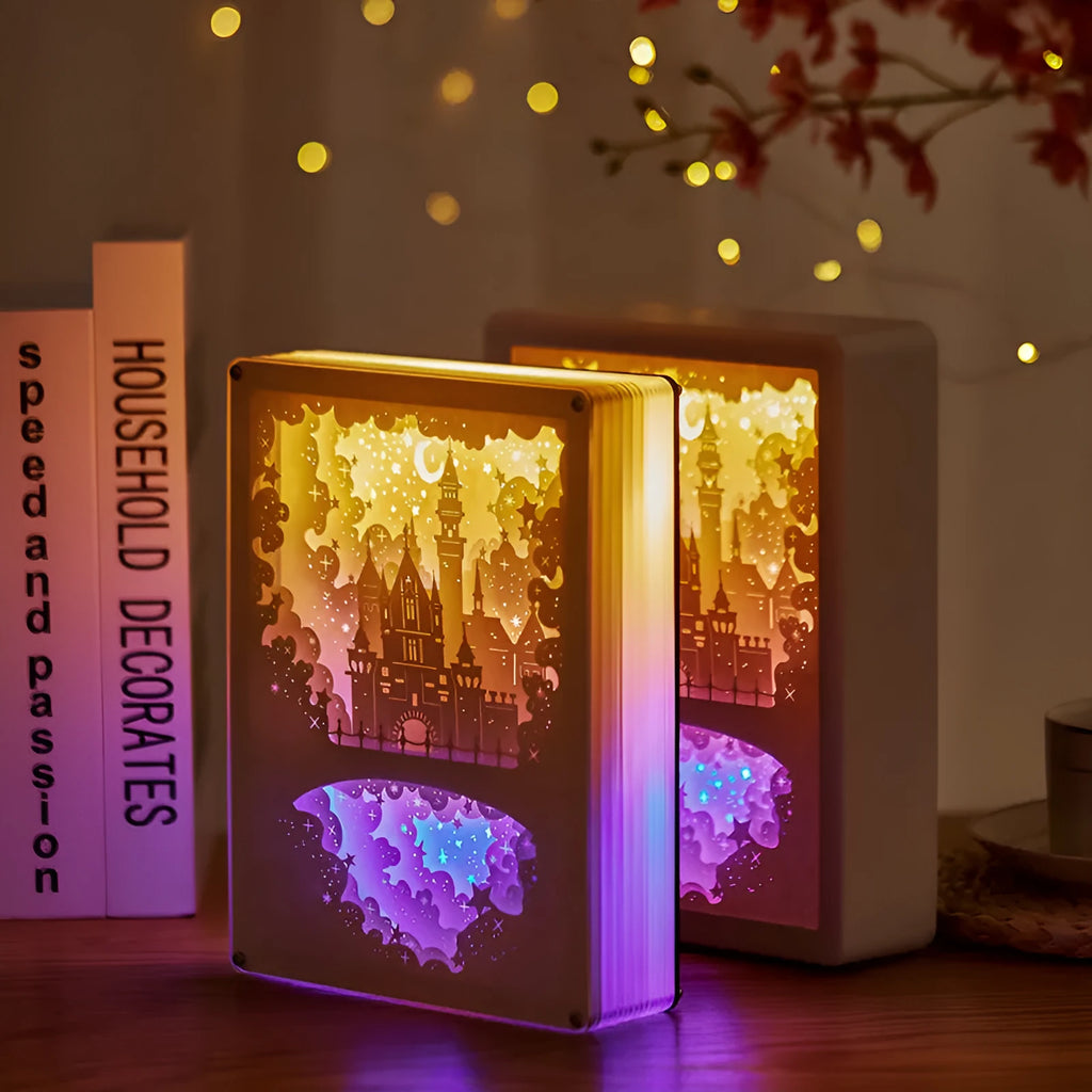 Modern romantic night light with three-dimensional paper carving design and remote control on a bedside table.