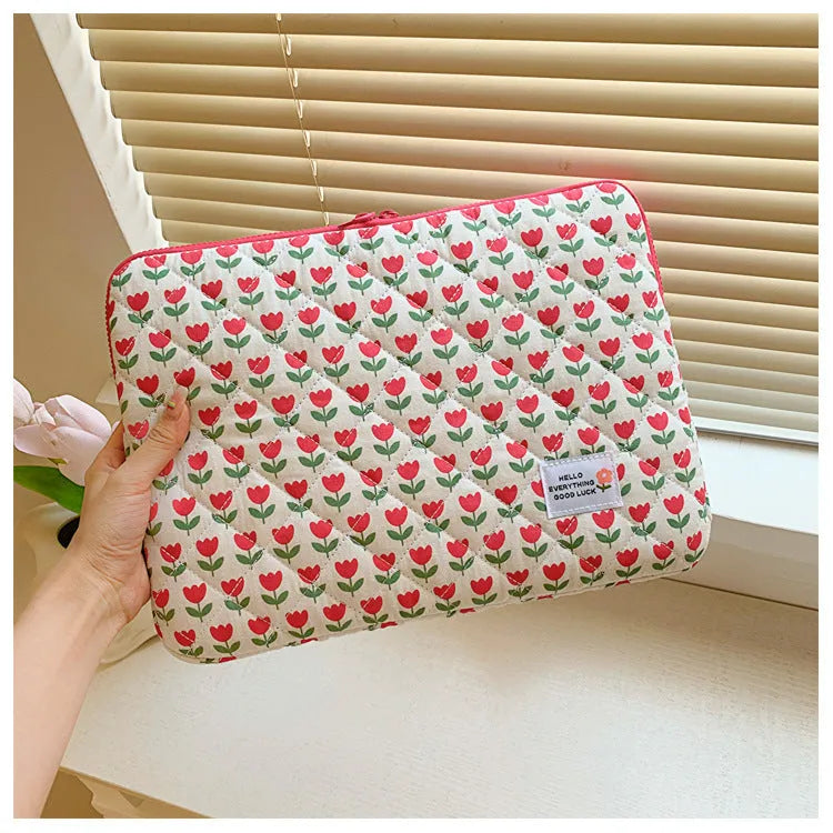 Floral print cloth laptop bag in green flower, pink floral, red flower, and red heart designs, showing three size options.