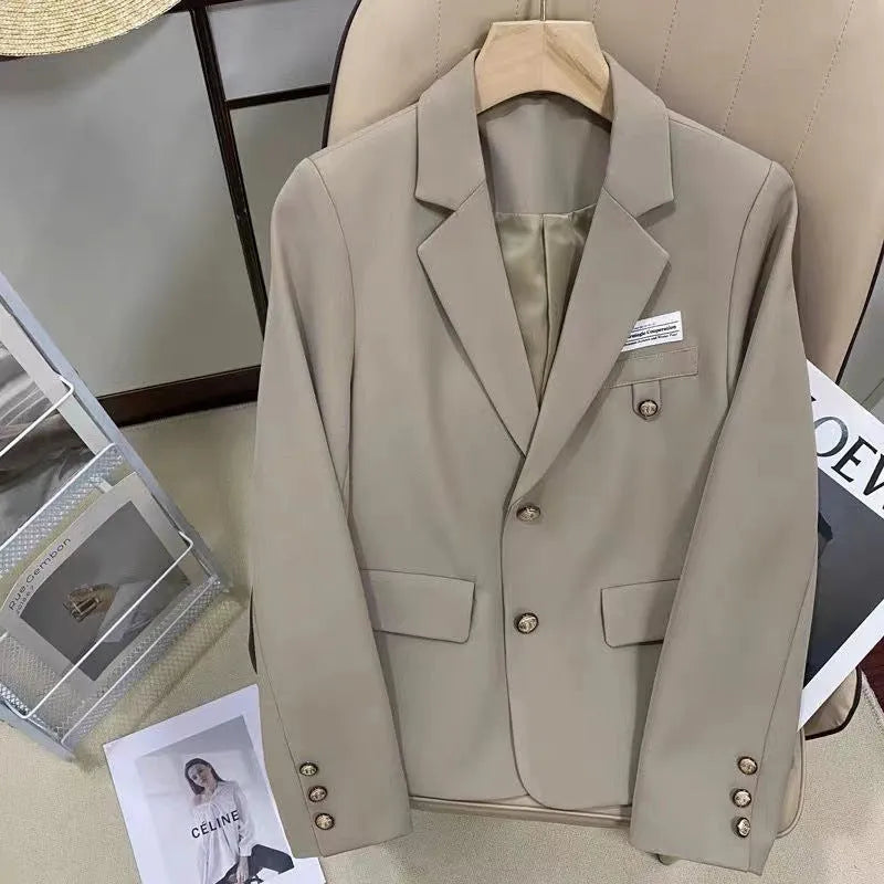 Black women's loose-fit short suit coat with long sleeves and pockets.