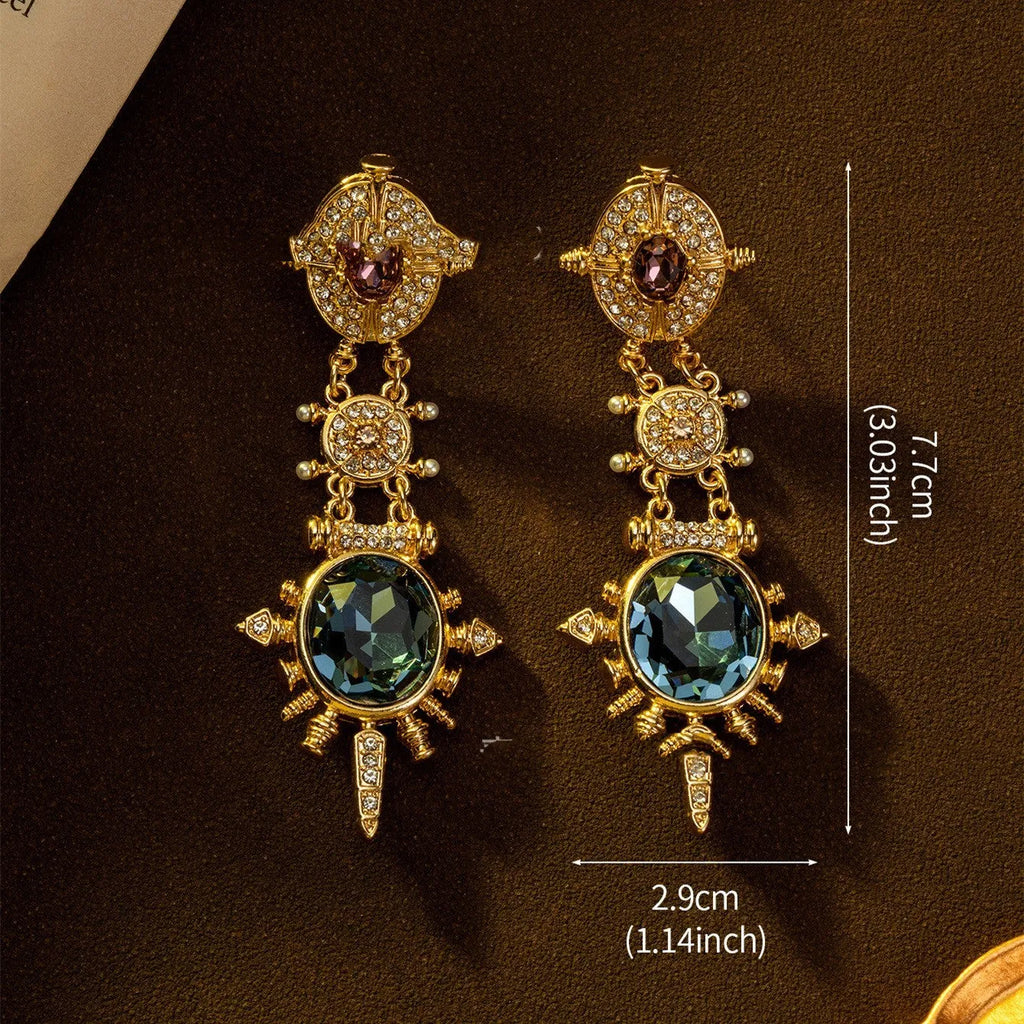 A pair of gold geometric round stud earrings with a diamond-treated finish on a white background.