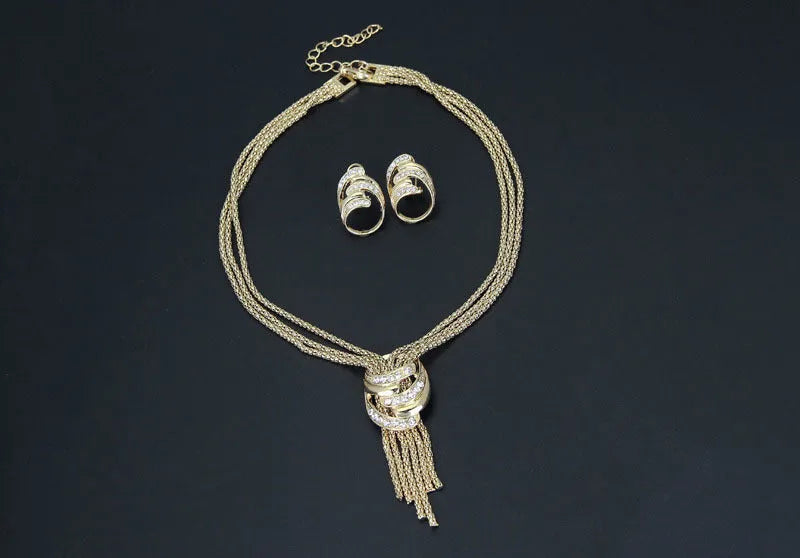 Gold alloy jewelry set with necklace, bracelet, earrings, and ring on a neutral background