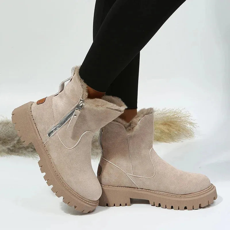 Women's black snow boots with foldable plush tube, suede upper, and rubber sole on winter pavement