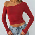 Women's black slim fit knitted cardigan with long sleeves and cross shoulder strap detail.