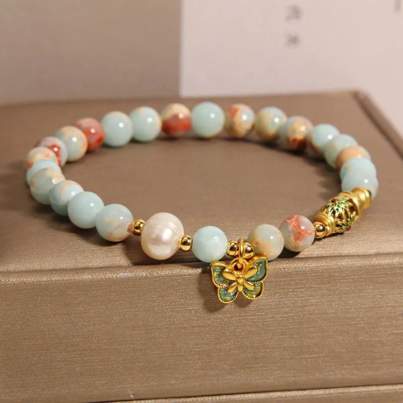 Shoushan stone and freshwater pearl bracelet with blue butterfly pendant on display