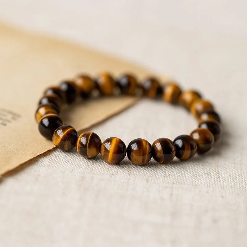 Single Tigereye Dzi bead Buddha rosary bracelet on wrist, showing simple ethnic design.