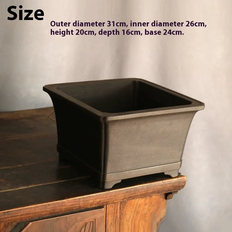 Purple sand square high basin flower pot with black ancient copper clay finish on a wooden table