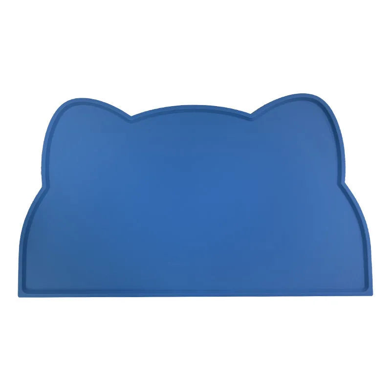 Blue silicone cat head-shaped pet feeding mat on a wooden floor.