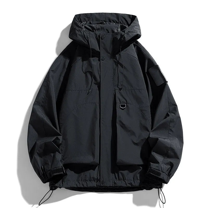 Man wearing a black hooded windproof waterproof jacket with long sleeves.