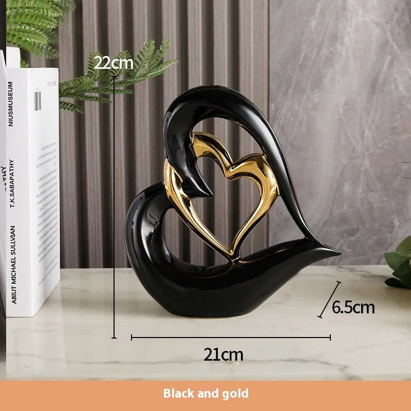 Modern white porcelain heart ornament in a metallic finish, showing its geometric shape on a table.