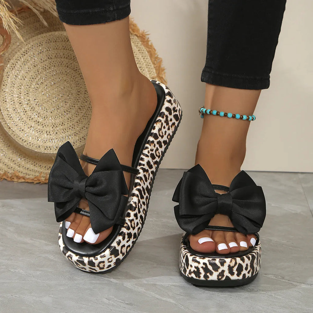 Women's black and white leopard print beach slippers with a thick platform sole.