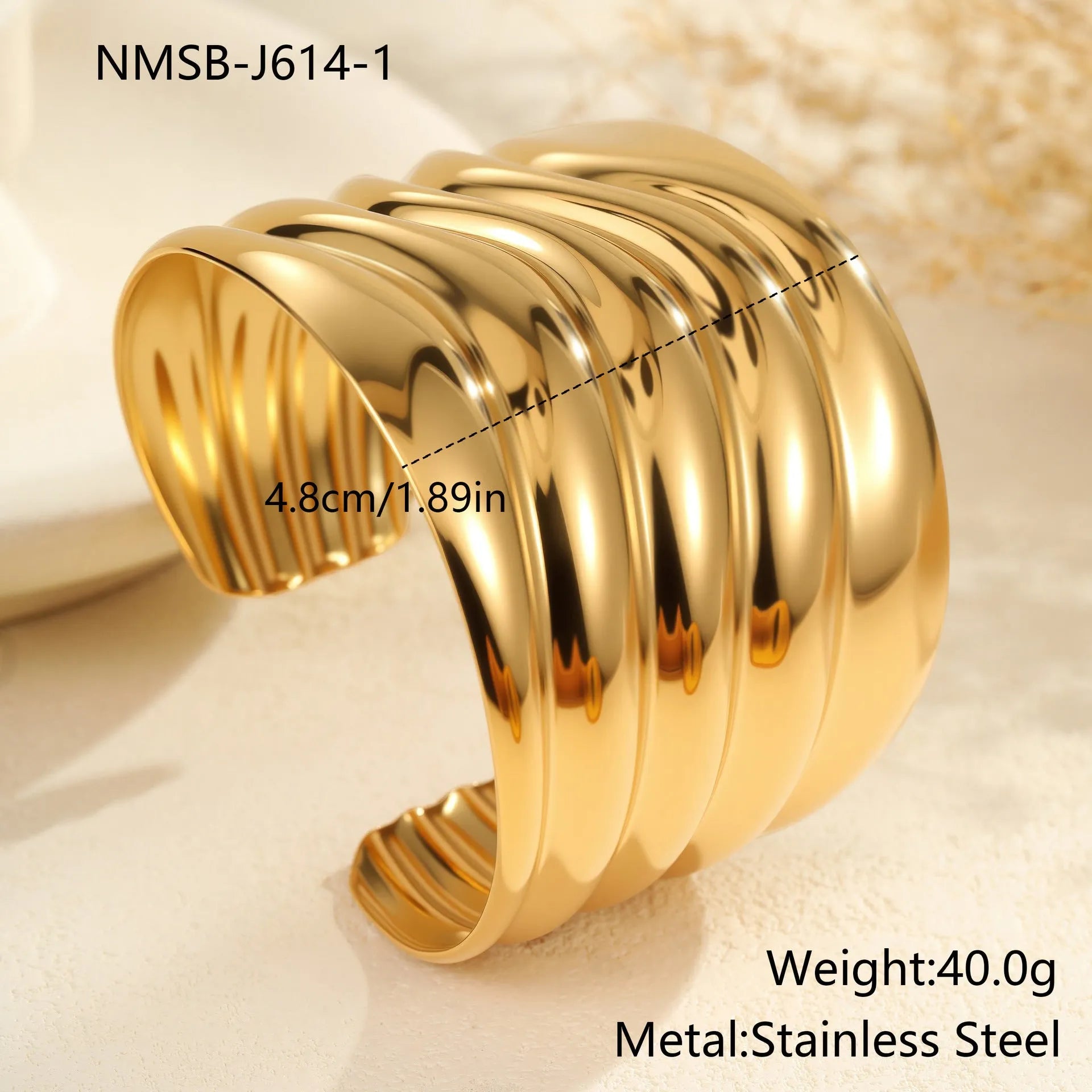 Gold plated wide stainless steel bracelet with a geometric wave shape and a niche opening.