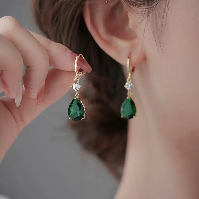 Green geometric teardrop alloy earrings on a white background.