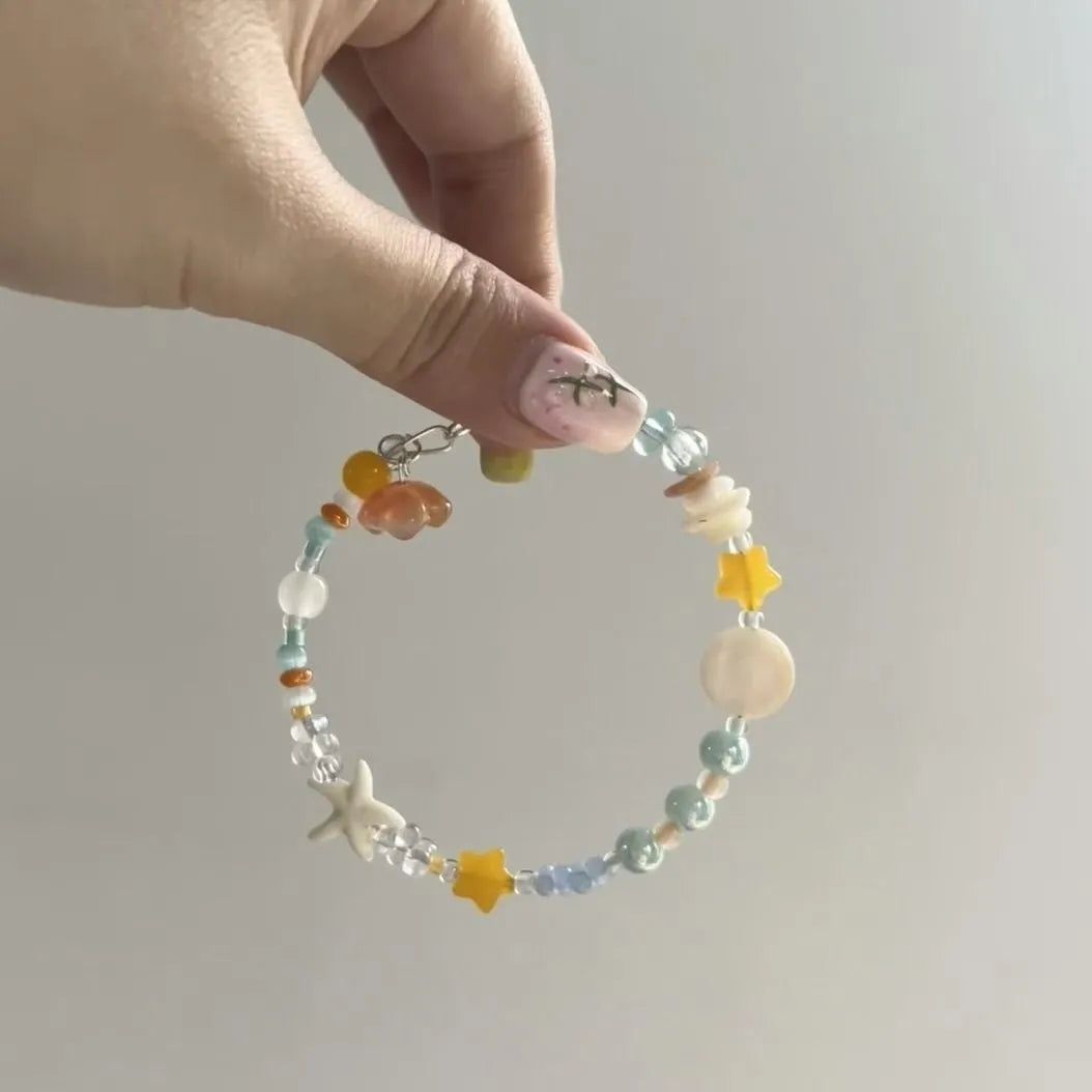 Orange seaside-inspired alloy bracelet with diamond charm and round elements showing water-soaked design aesthetic