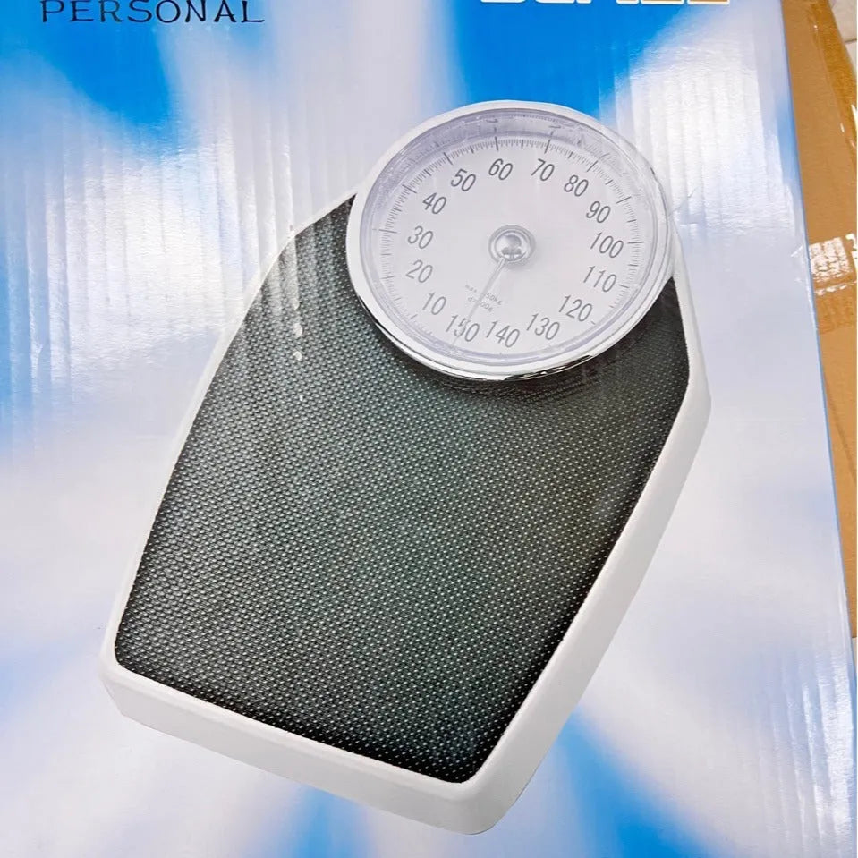 Black mechanical bathroom scale with large analogue dial display on white background