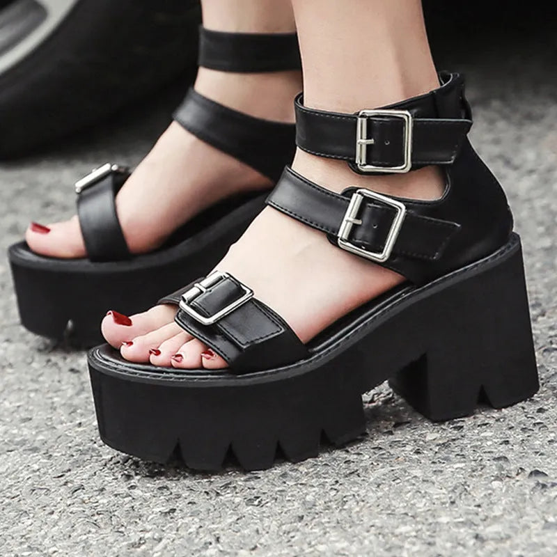 Black women's punk-style sandals with chunky heel, round toe, back zipper, and decorative buckle.