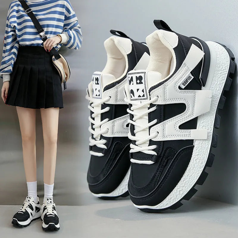 A pair of solid-colour low-top lace-up sneakers with a round toe and flat rubber sole.