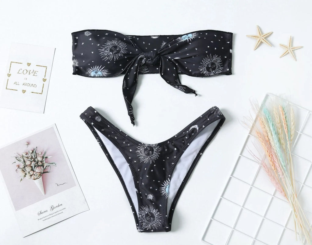 Black bikini print one-piece swimsuit with a split tube top and backless design.