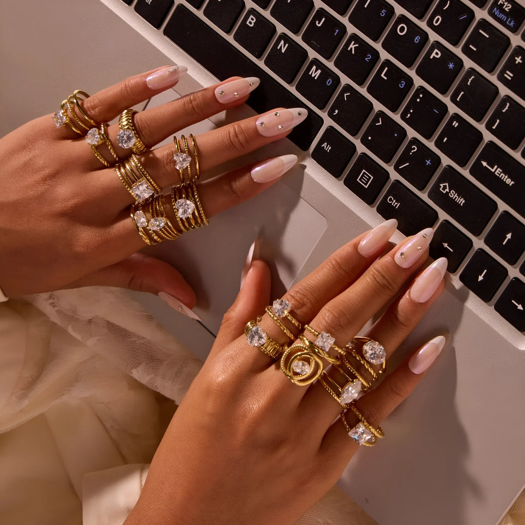 Gold-coloured adjustable stainless steel ring with zircon geometric shapes on white background.