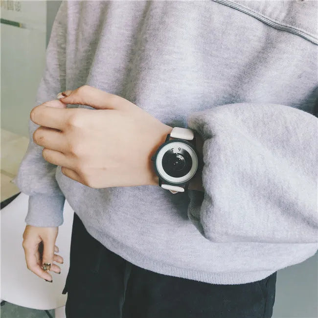 Casual unisex handless watch with pointer display, round dial, alloy case, and imitation leather strap on wrist