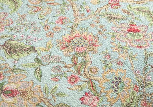 Blue American floral pattern cotton quilted bedspread set with three pieces on a bed