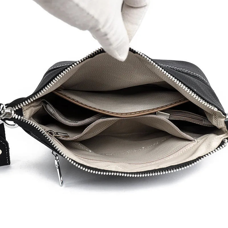 Genuine leather crossbody bag in black with spliced design and multiple internal pockets