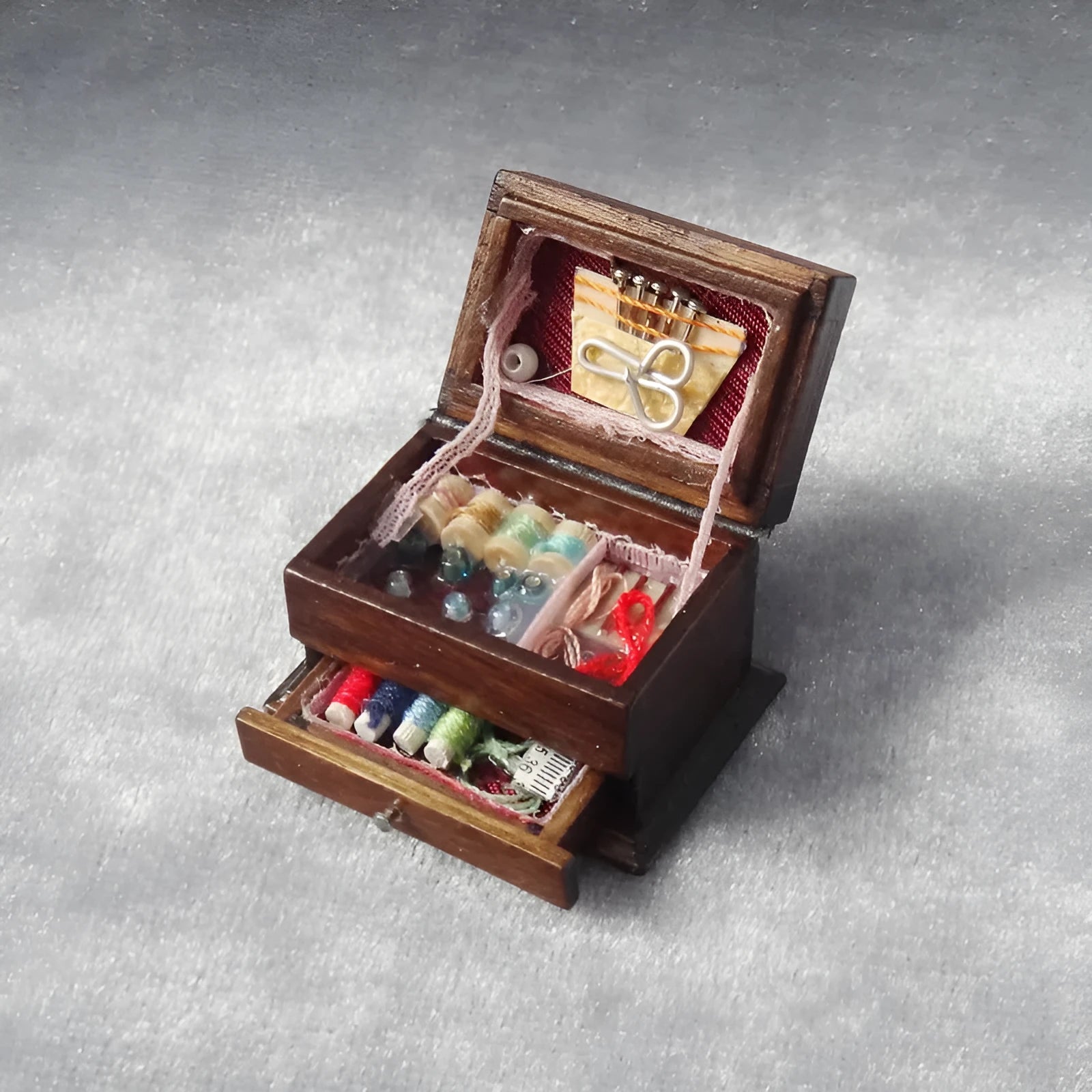 Miniature wooden vintage sewing machine sewing kit with double layer colour design on a white background.