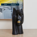 Modern black and white resin vase with sculpted body shape on living room table