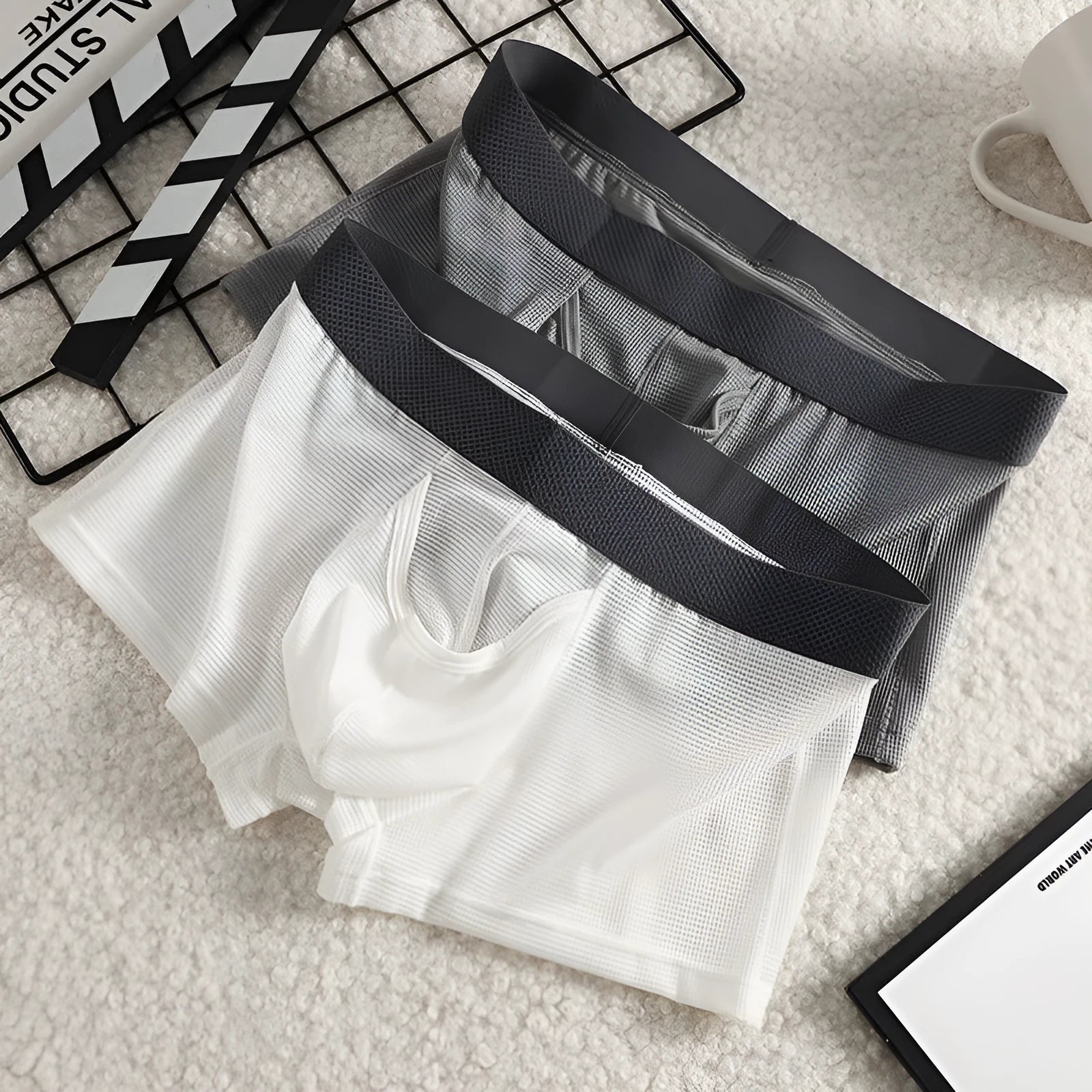 Men's solid colour ice silk boxer briefs with a low waist and mesh knit fabric.
