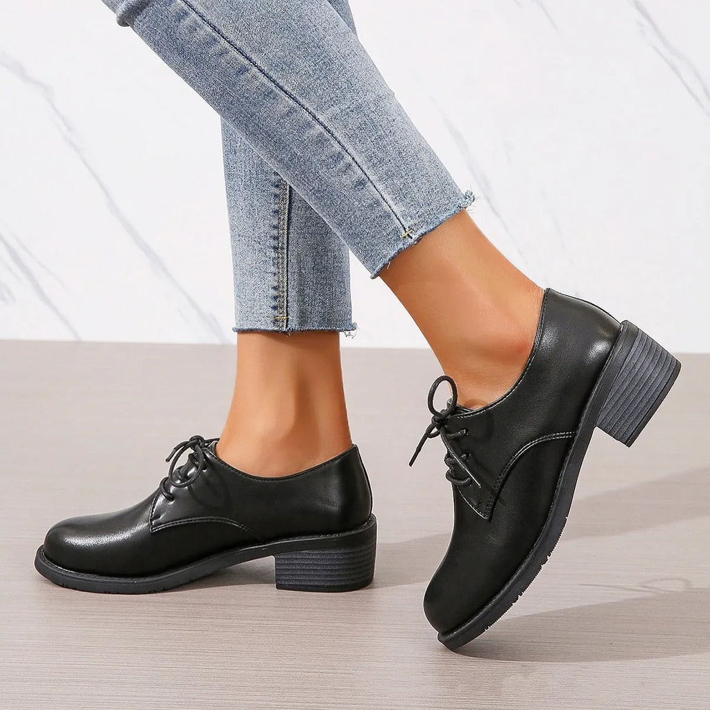 Black women's low-top work shoes with a chunky heel, PU leather upper, and rubber sole.