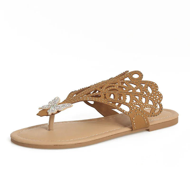 Women's black slip-on sandals with rhinestone detail, hollow-out design, and flat rubber sole.