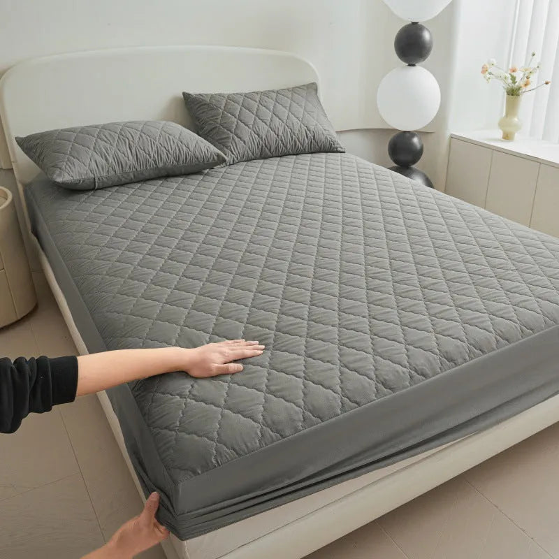 Diamond lattice quilted waterproof mattress protector and pillowcases in a solid colour.