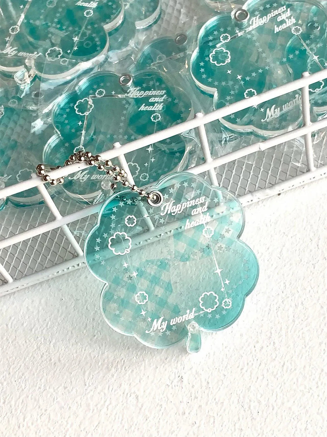 Acrylic four-leaf clover phone pendant keychain on a ring in blue, green, or mint.