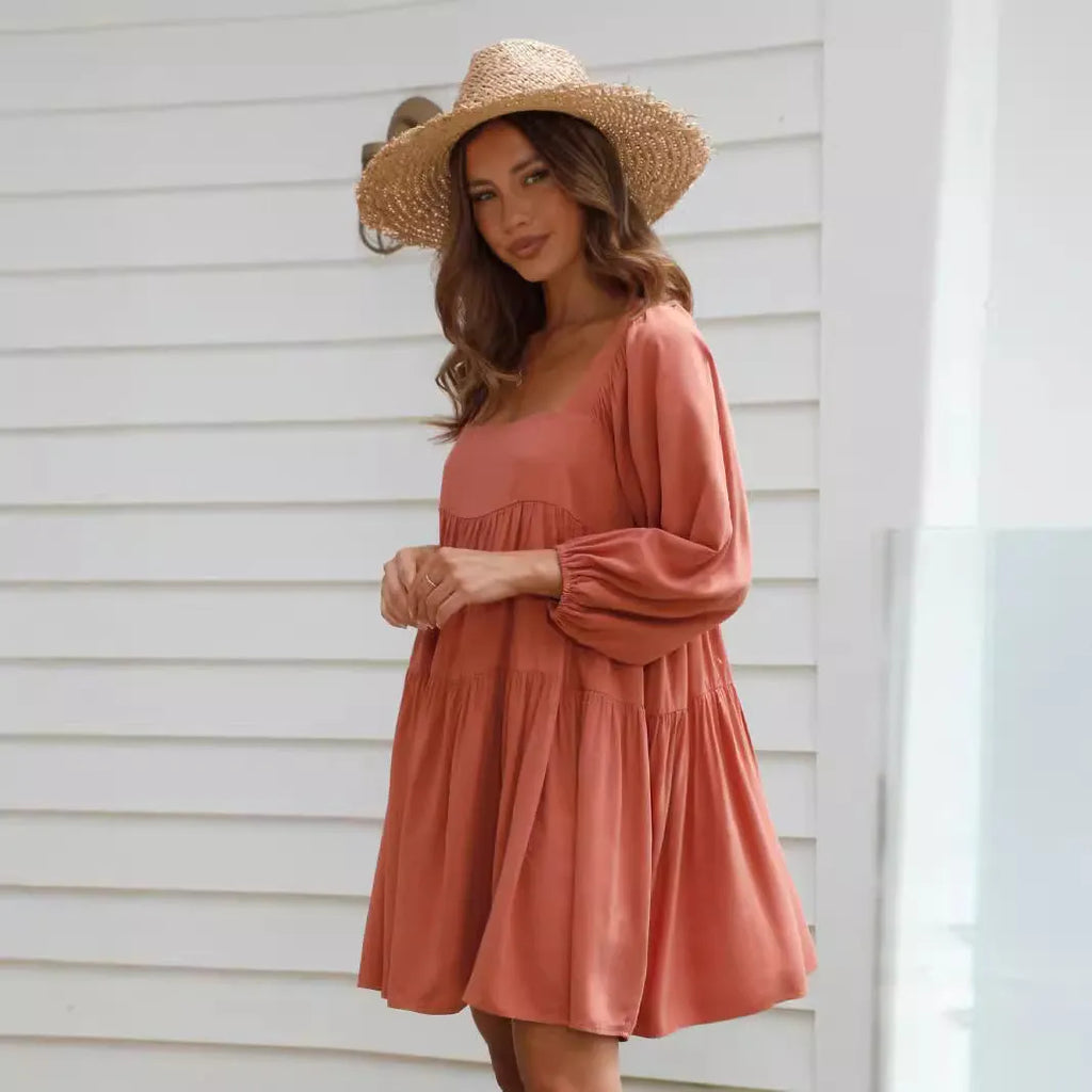 A child's orange puff sleeve dress with a square collar and backless design, featuring an A-line silhouette.