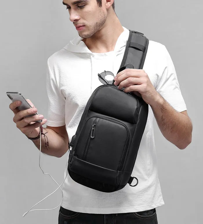 Black PVC outdoor shoulder bag showing medium size, shoulder strap, and internal pocket organisation