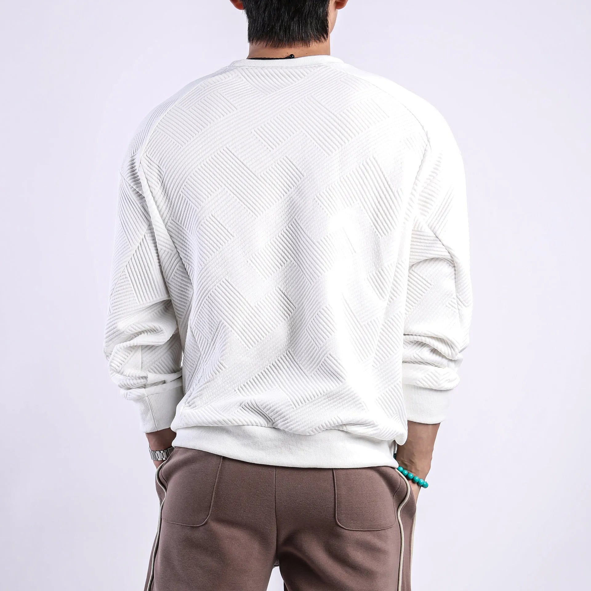 Man wearing a loose-fit army green twill jacquard long-sleeved pullover sweater.
