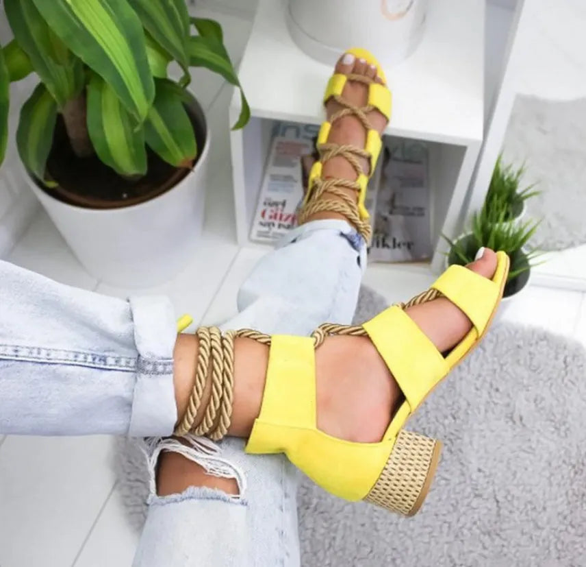Women's beige suede sandals with thick heel, front strap, and ankle strap on a white background.