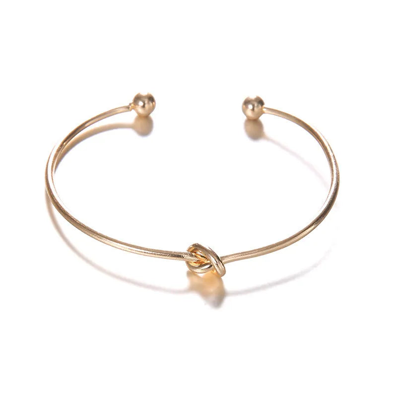 Gold electroplated alloy vintage cuff bracelet with arrow and knot design for women