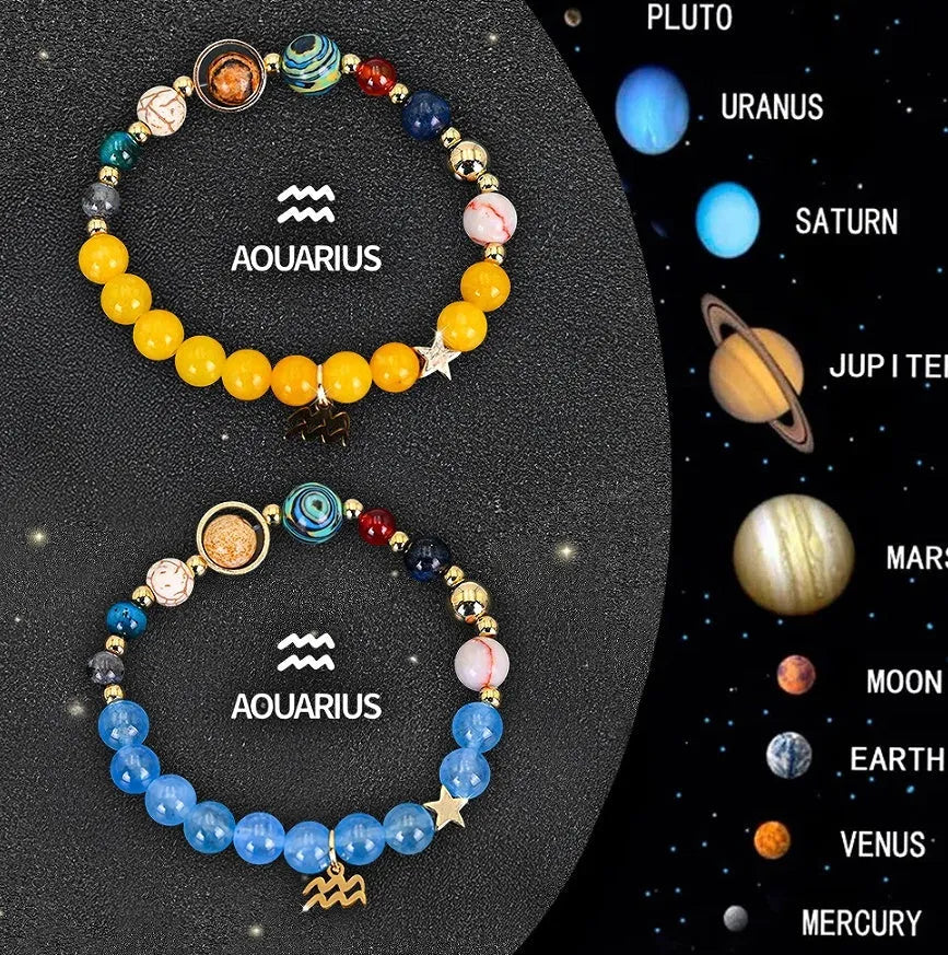 Two natural stone beaded bracelets with zodiac sign charms on a wooden surface