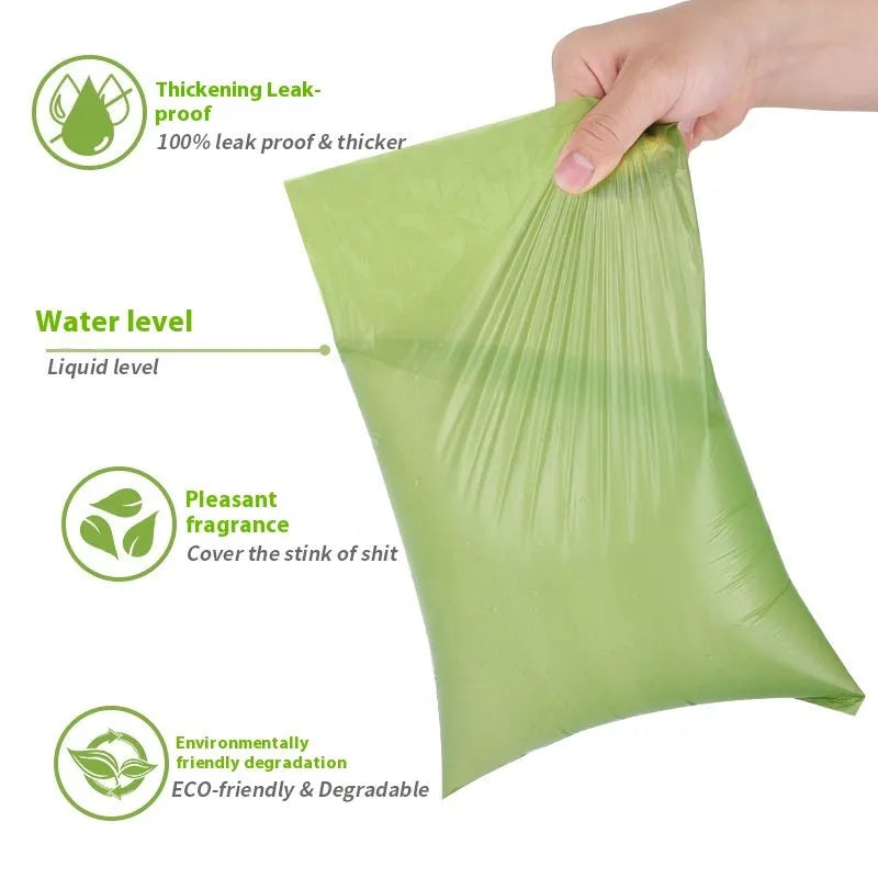 Roll of green EPI degradable dog poo bags next to a white plastic dispenser on a grass background.