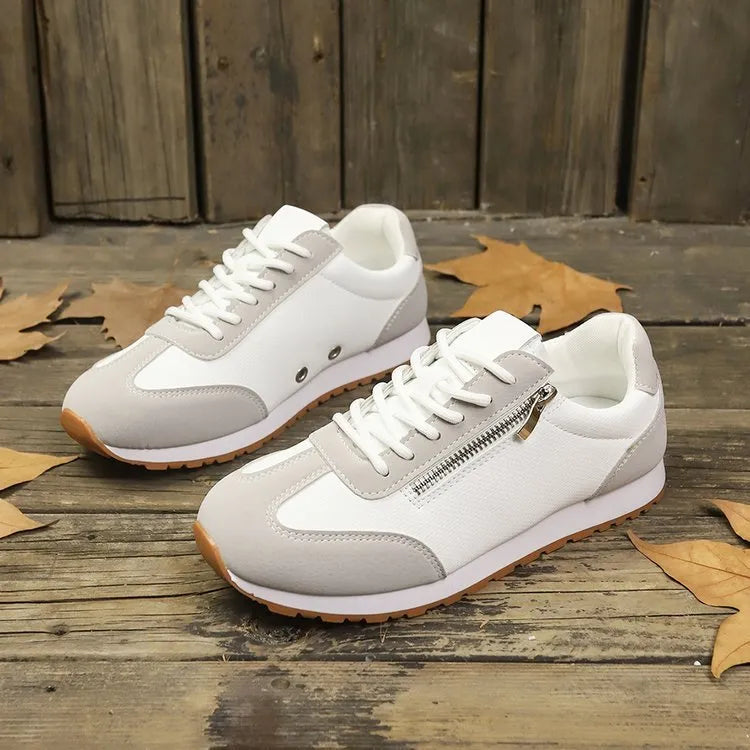 Women's grey flat-heeled shoes with artificial PU upper and rubber sole on a plain background.