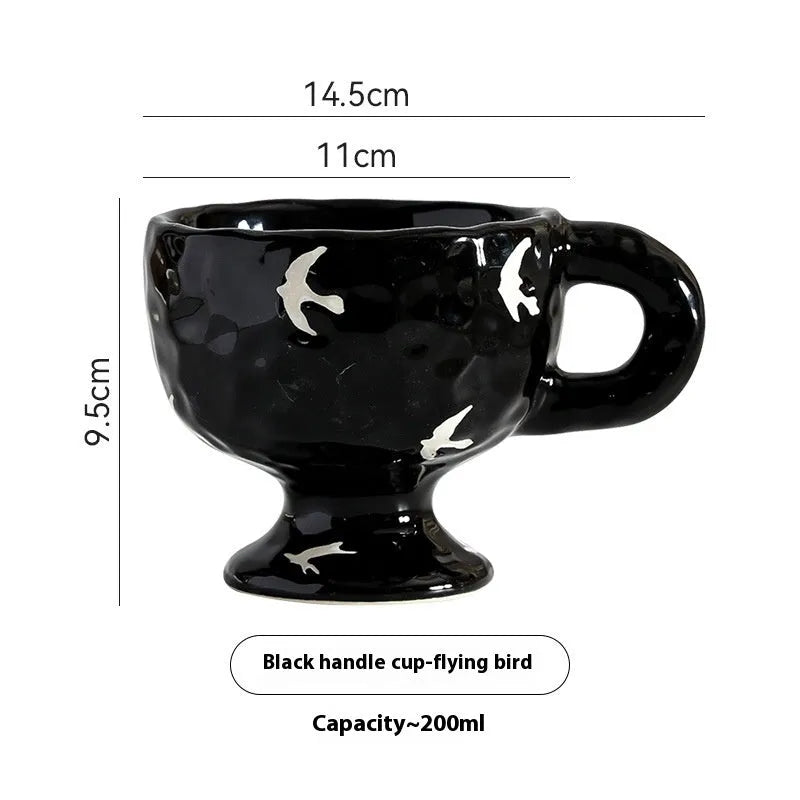Hand-pinched irregularly shaped ceramic mug in a solid colour, shown on a table.