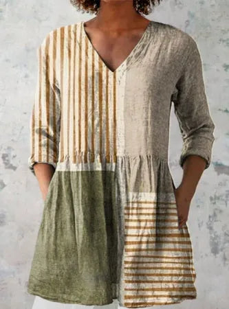 A woman wearing a loose-fitting printed dress with 3/4 sleeves and a wide waist.
