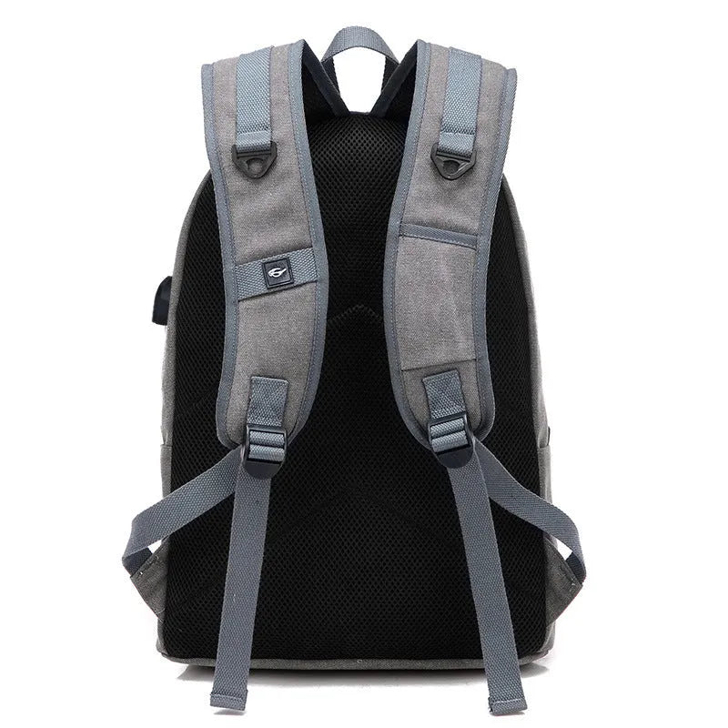 Canvas backpack with USB charging port showing multiple compartments including laptop pocket