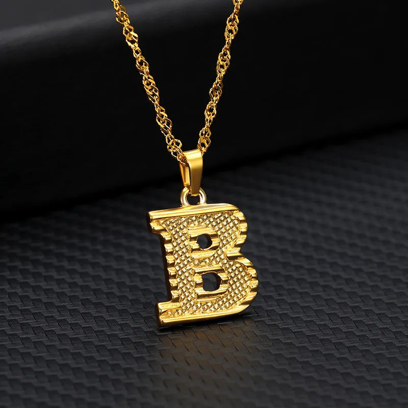 Gold-plated alloy initial pendant necklace with 42cm chain on white background