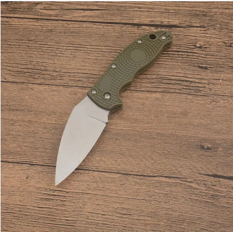 Portable folding fruit knife with black handle and silver 9CR13MOV blade on a wooden surface